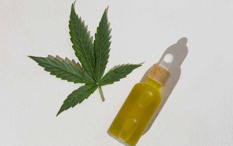 CBD Oil bottle and cannabis leaf