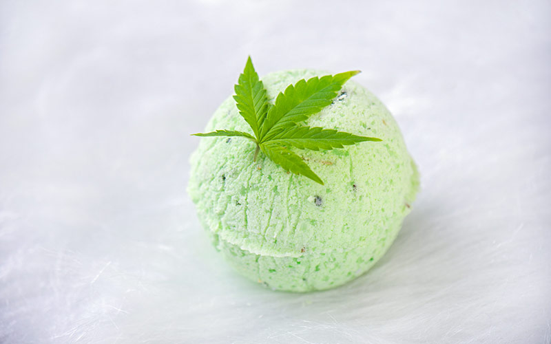 Round green cannabis bath bomb with cannabis leaf isolated on white background