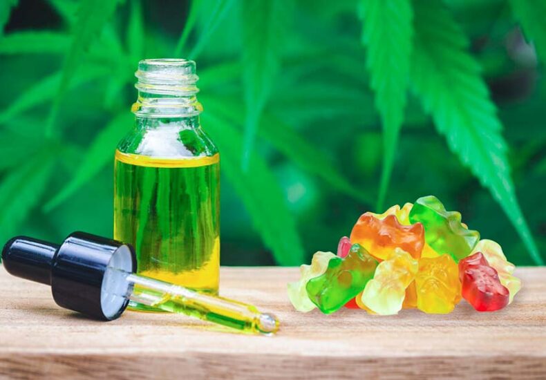 CBD oil bottle with dropper and cbd gummies on the table