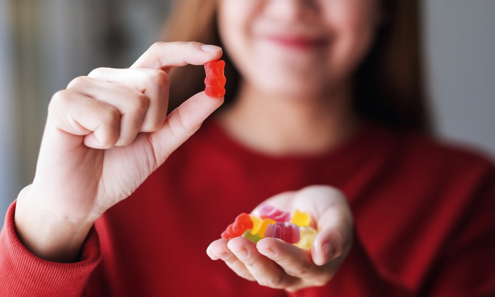 A Girl Looking at a Piece of Gummies
