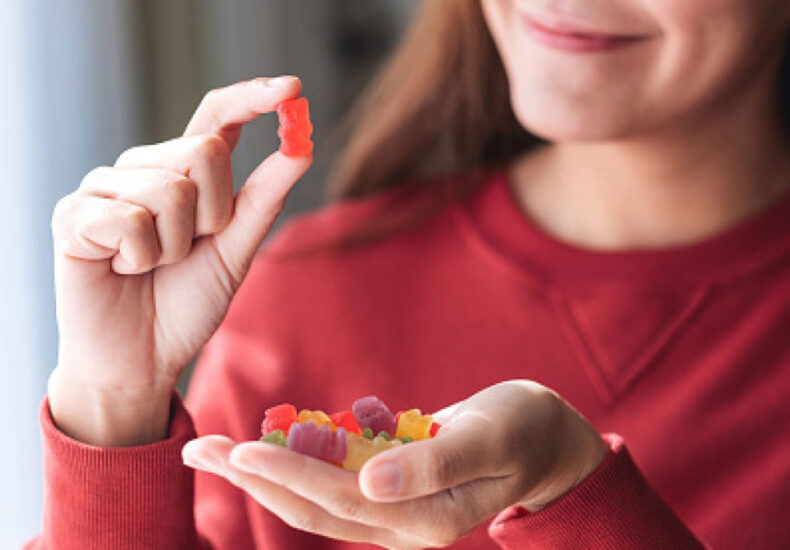 A Woman Looking at the Gummies on her hand