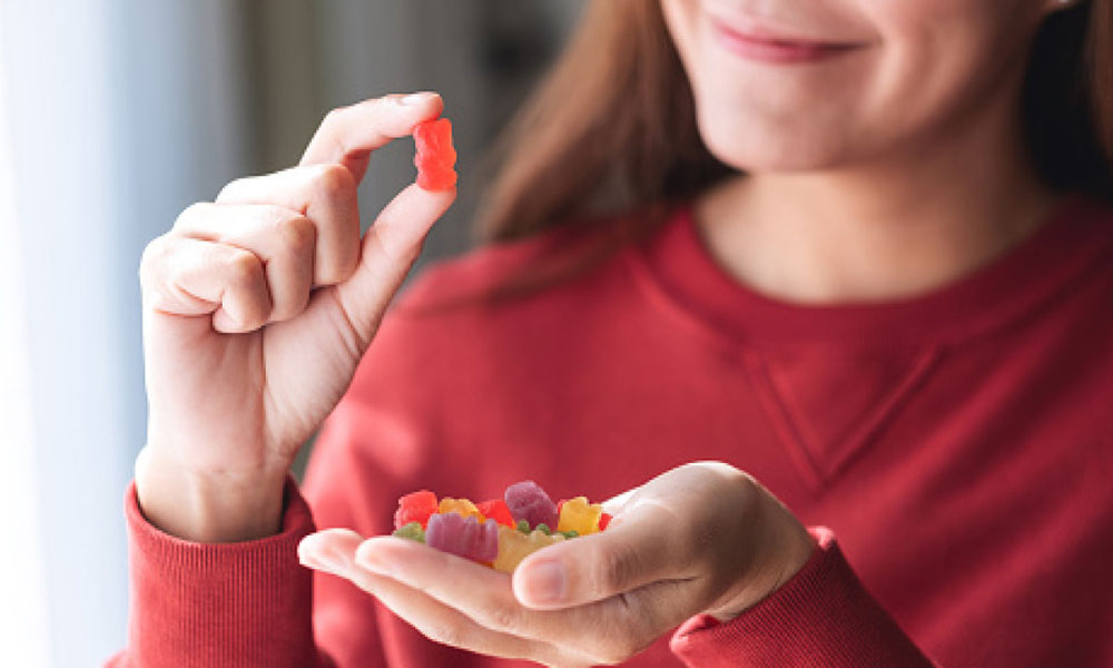 A Woman Looking at the Gummies on her hand
